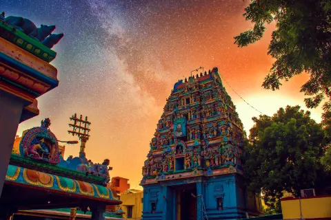 Painted gopuram of a South Indian temple at sunset